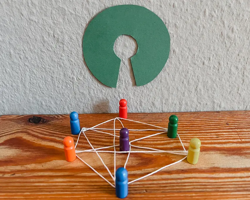 Mehrere Spielfiguren sind durch Fäden netzartig miteinander verbunden. Darüber ist das grüne Open-Source-Logo zu sehen.