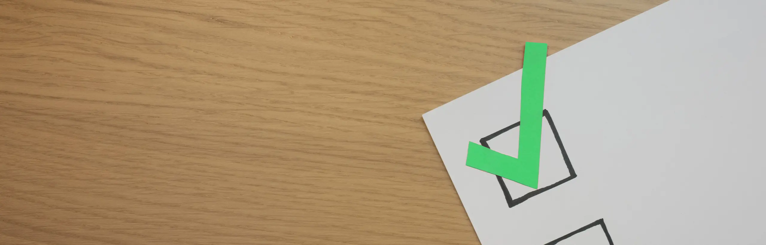 Papierblatt mit großen Checkboxen und einem grünen Haken