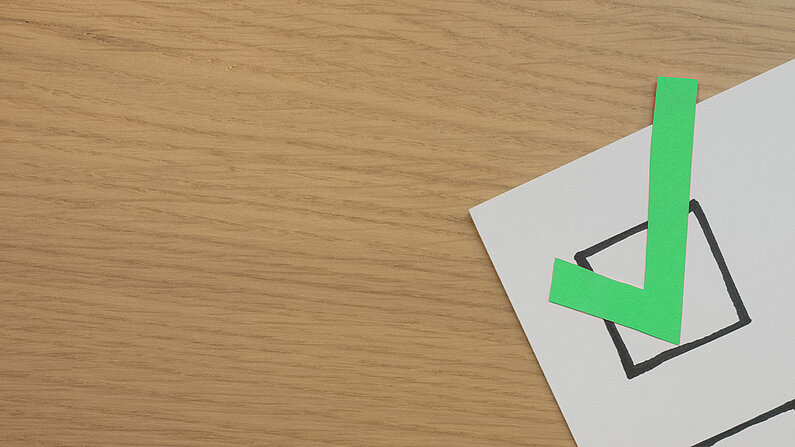 Papierblatt mit großen Checkboxen und einem grünen Haken