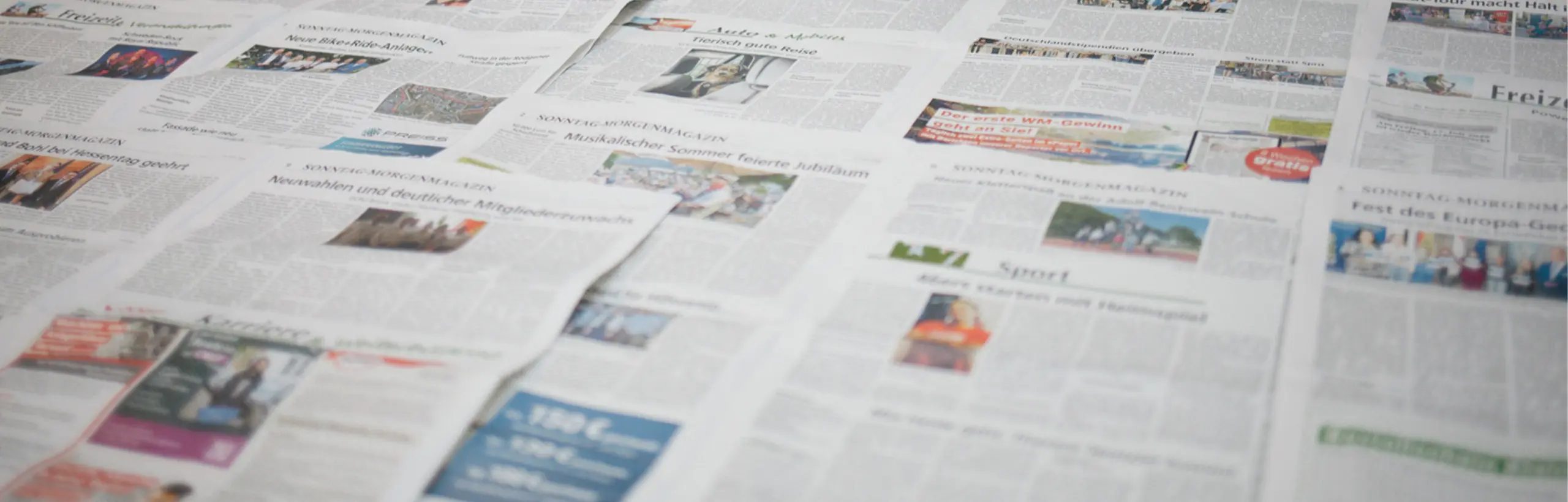 Nahaufnahme mehrerer sich überlappender Zeitungsartikel.