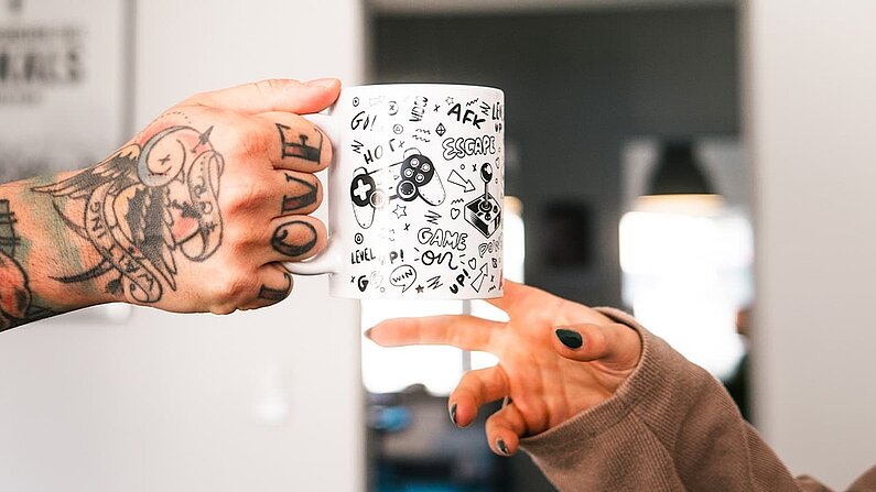 Mitarbeiter überreichen eine Kaffeetasse