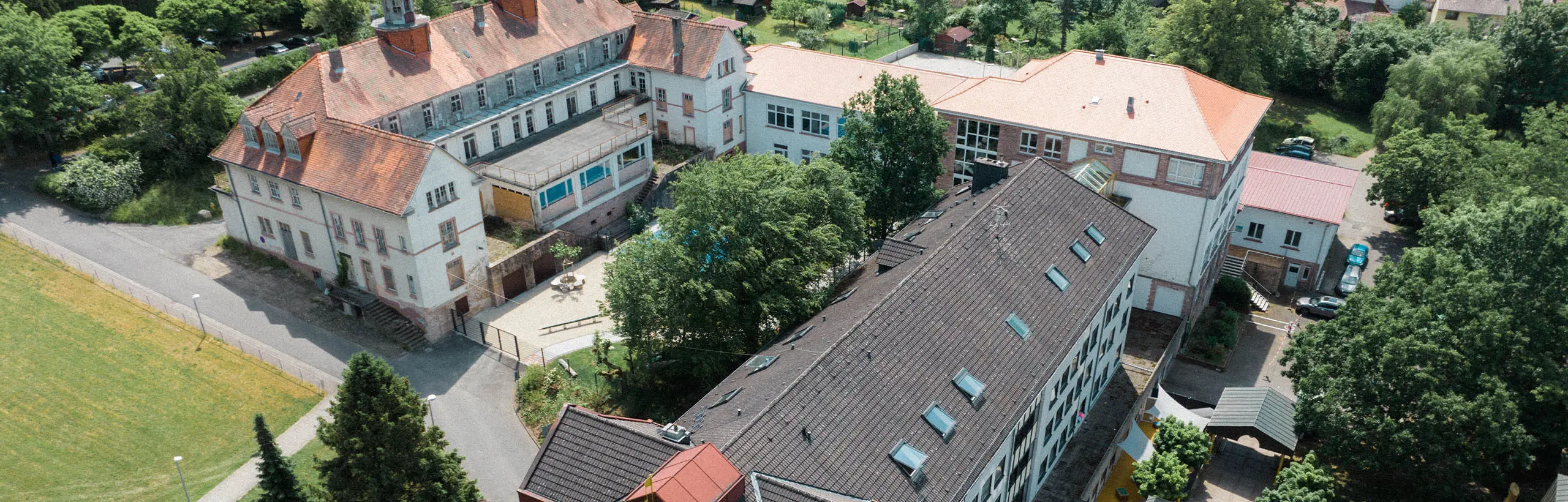 Schräge Vogelperspektive auf den Gebäudekomplex der Spessartklinik. Drei längliche Gebäude umrahmen einen Innenhof.
